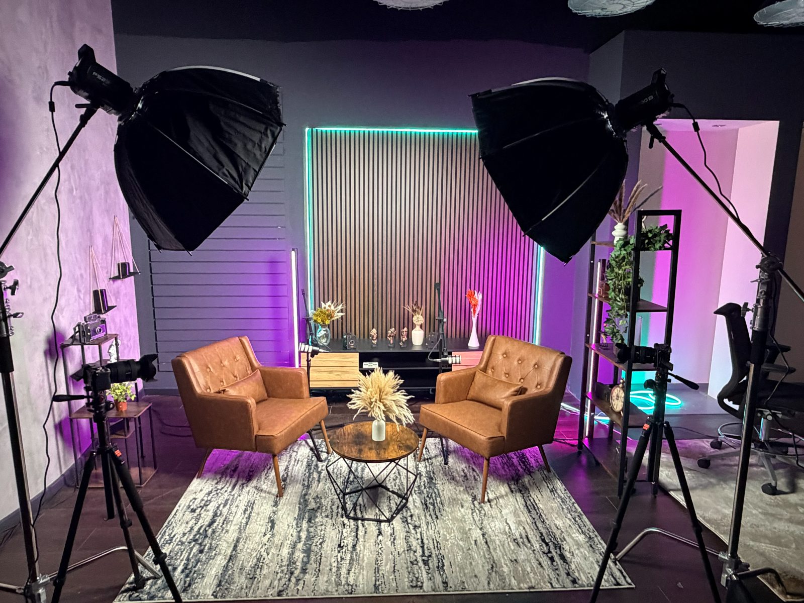 Podcast Studio Manchester — the lounge set with two tan leather armchairs, twin softboxes and RGB wall lighting